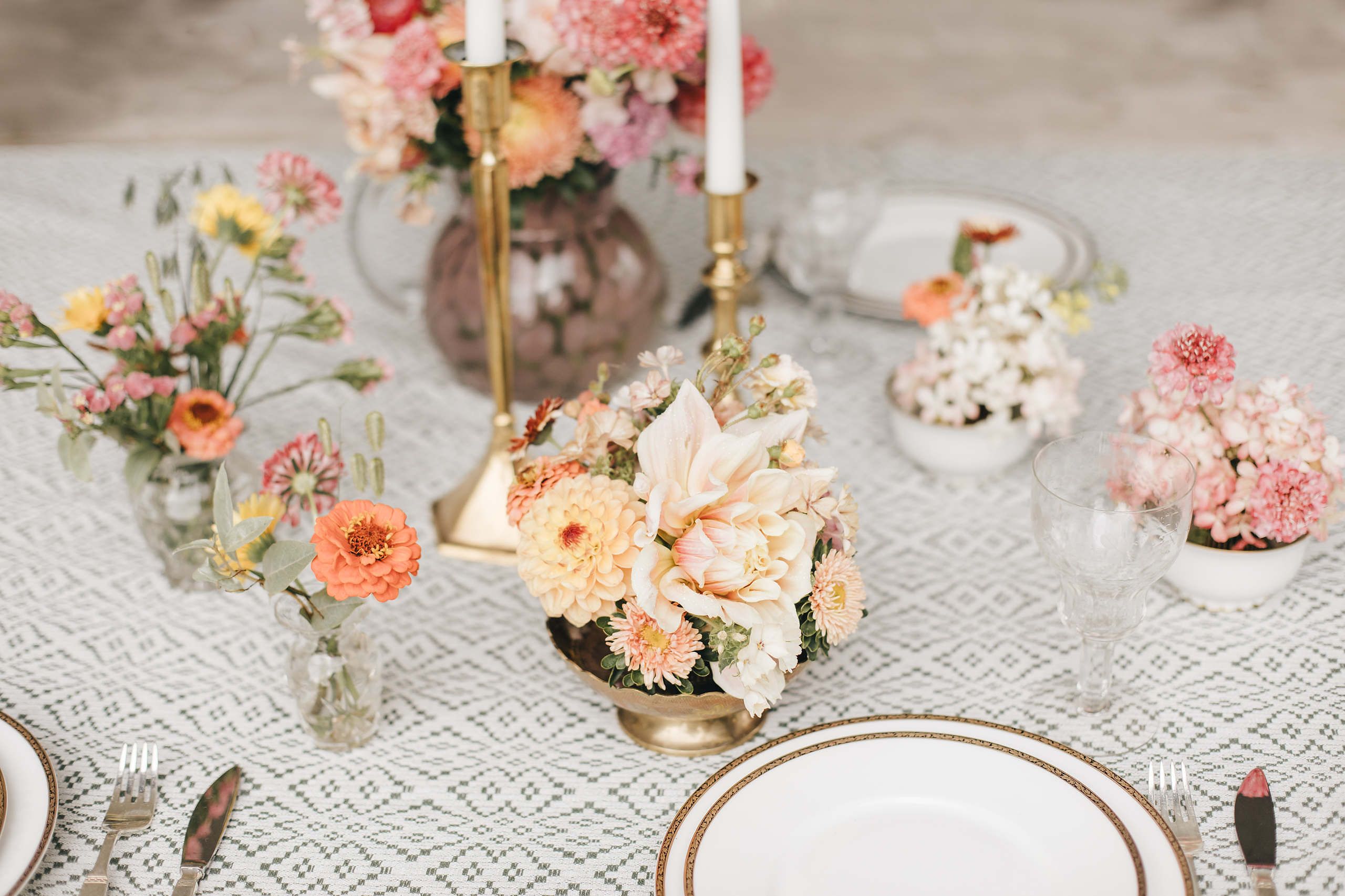 Dukat bord med små blomsterarrangemang och ljusstakar